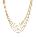 Seven delicate gold-plated snake chains create an elegant layered necklace on a neutral background.