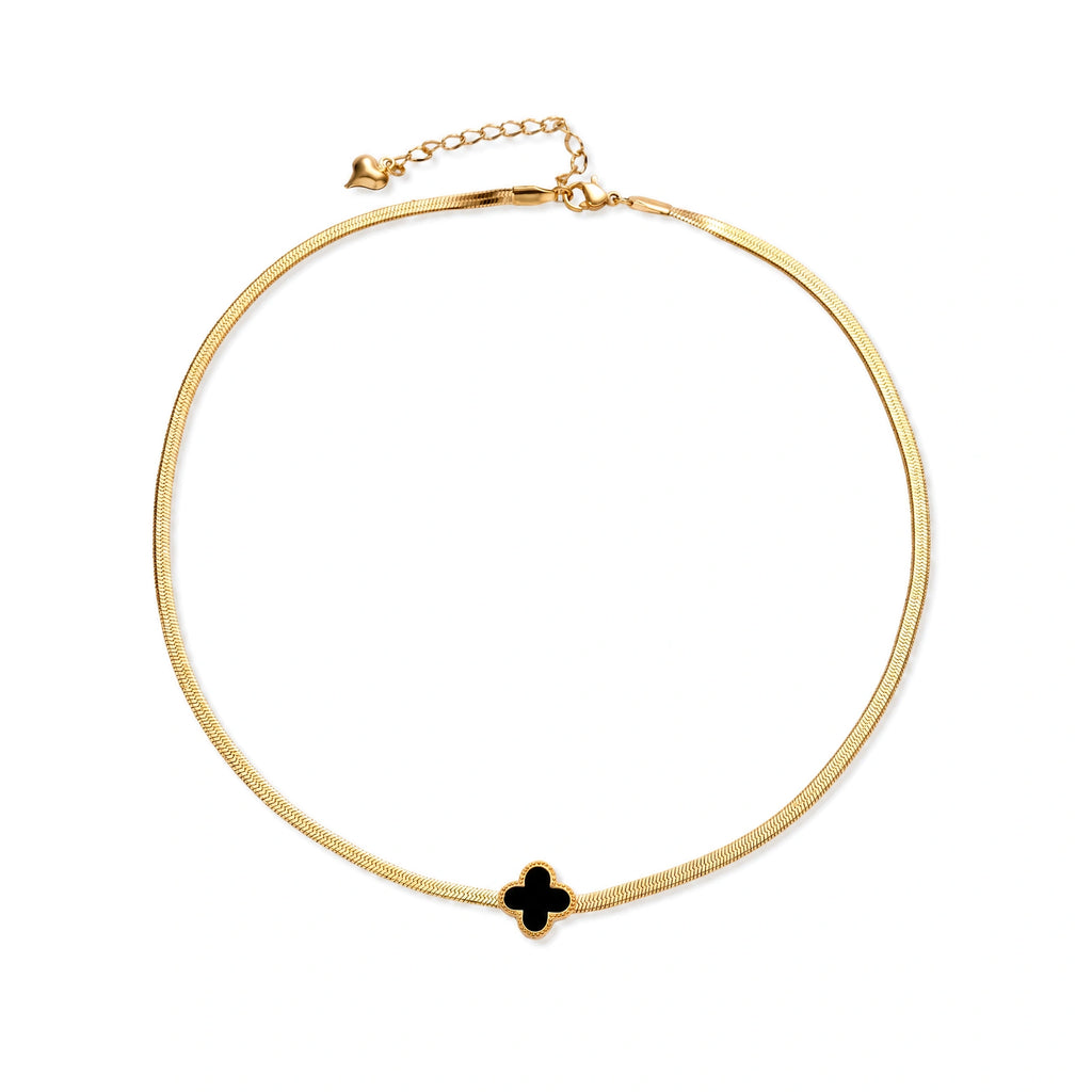 Dainty 18K gold-plated herringbone chain necklace with black enamel quatrefoil clover pendant on white background