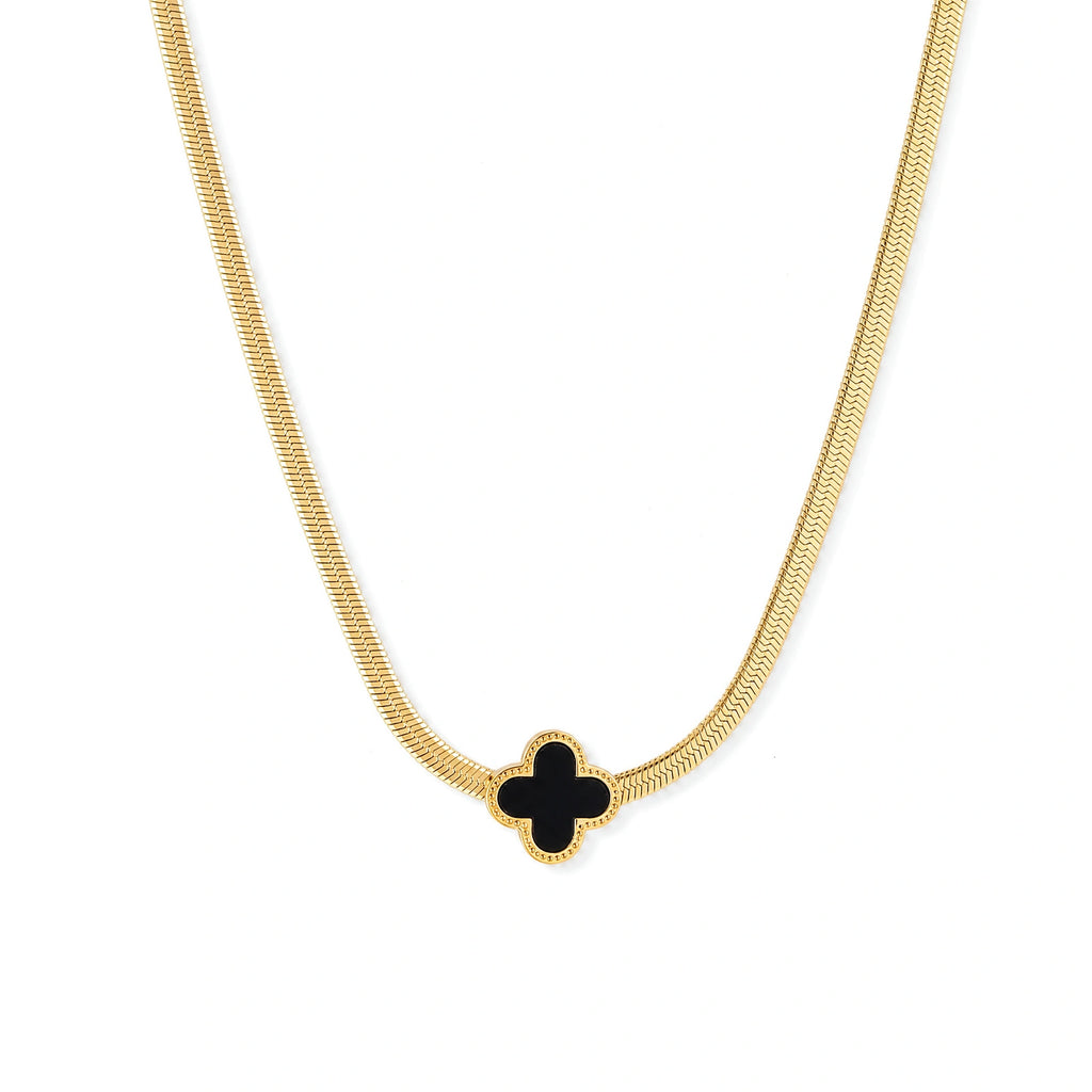 Dainty 18K gold-plated herringbone chain necklace with black enamel quatrefoil clover pendant on white background