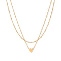 Delicate double-chain gold necklace with tiny heart pendant on cream background