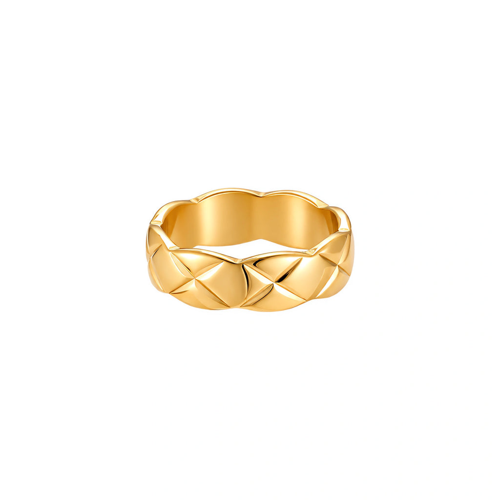 Close-up of an 18K gold-plated twisted band ring with dimensional braided pattern on cream background.