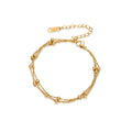 Three-strand gold-plated bracelet with clustered ball beads and adjustable clasp on cream background