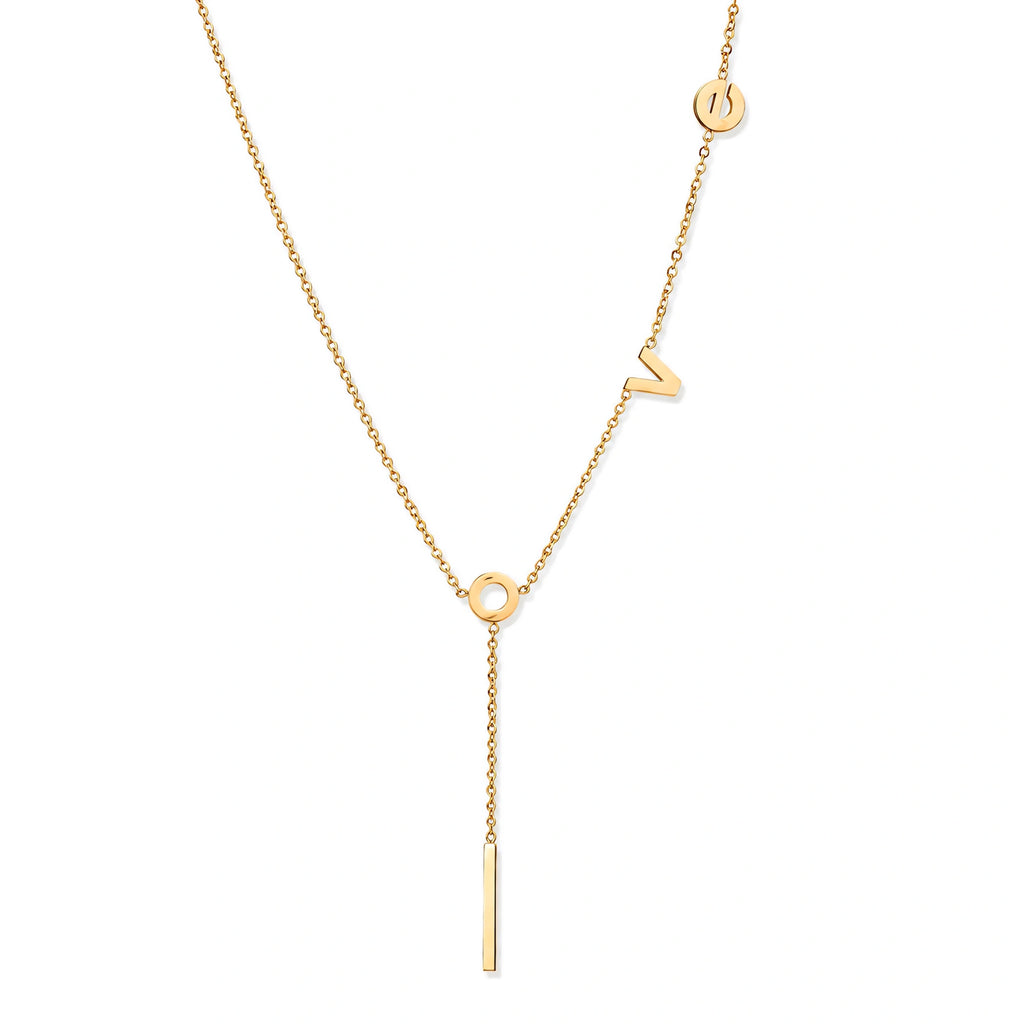 Gold Y-shaped necklace with L-O-V-E letter charms and vertical bar pendant on delicate chain against cream background