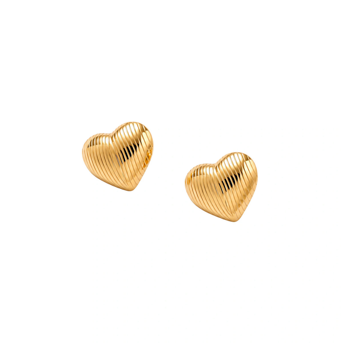 Gold heart-shaped stud earrings with parallel ridged texture on cream background