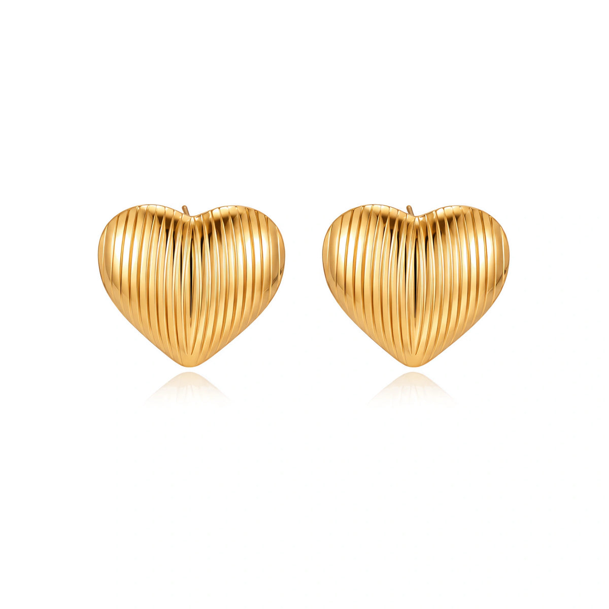 Gold heart-shaped stud earrings with parallel ridged texture on cream background