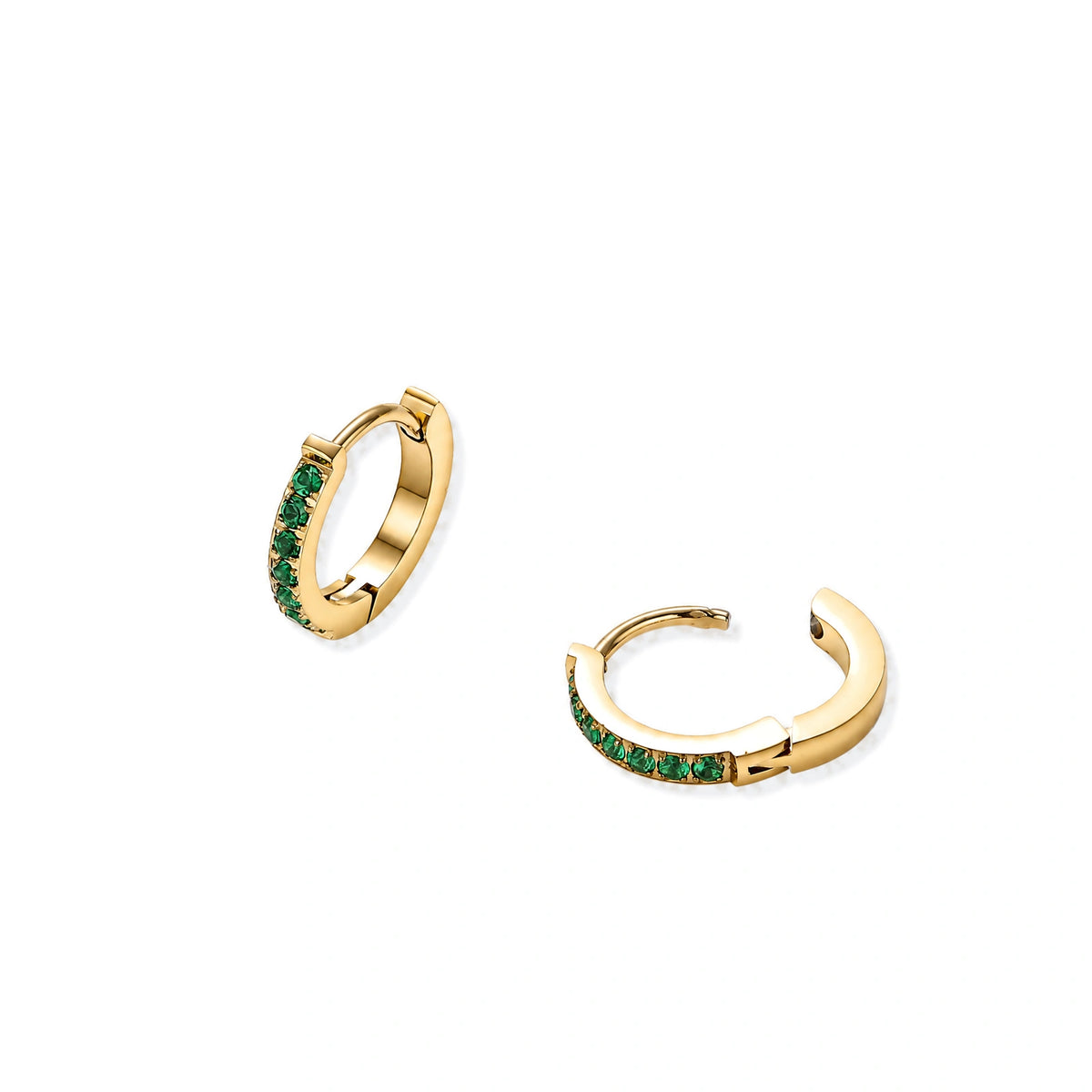 Pair of small gold huggie hoop earrings with bright green cubic zirconia stones on cream background