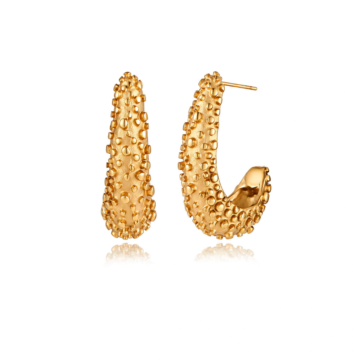 Curved gold hoop earrings with raised granulated texture resembling sea urchin surface on cream background