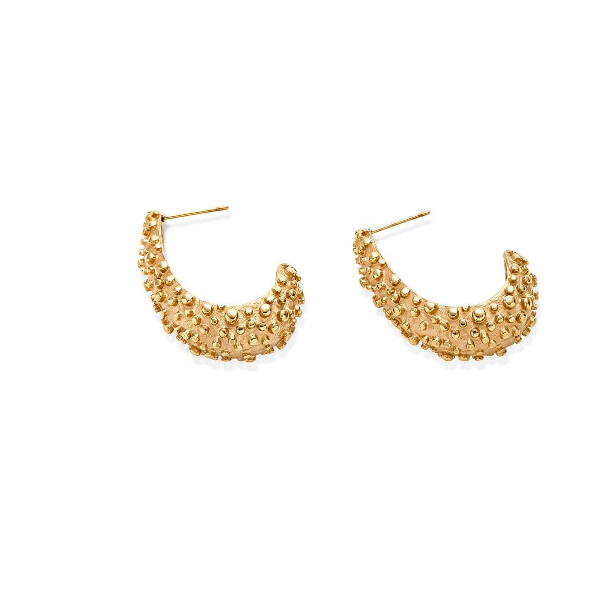 Curved gold hoop earrings with raised granulated texture resembling sea urchin surface on cream background