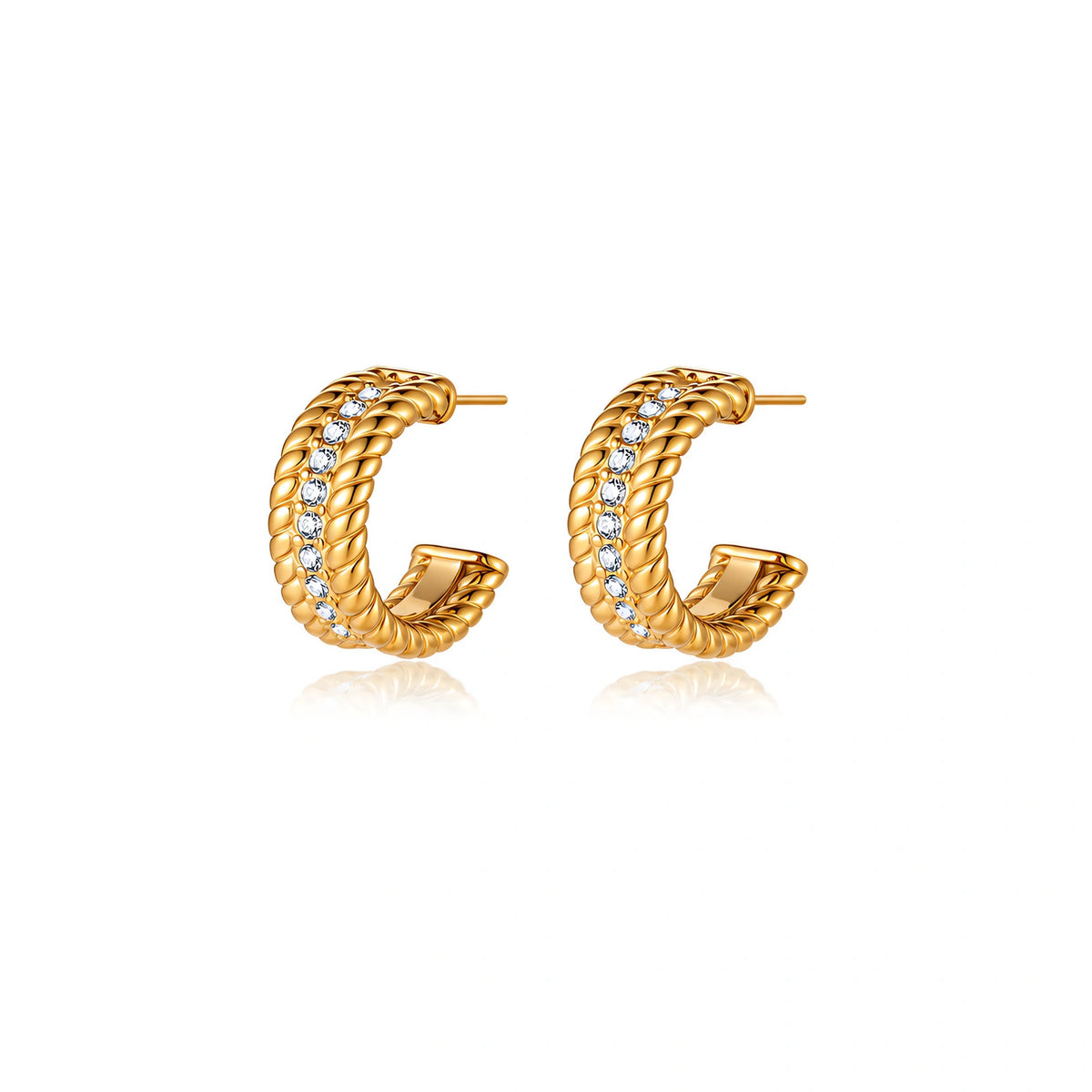 Textured gold huggie hoop earrings with raised ribbed rows creating dimensional sculptural design on cream background