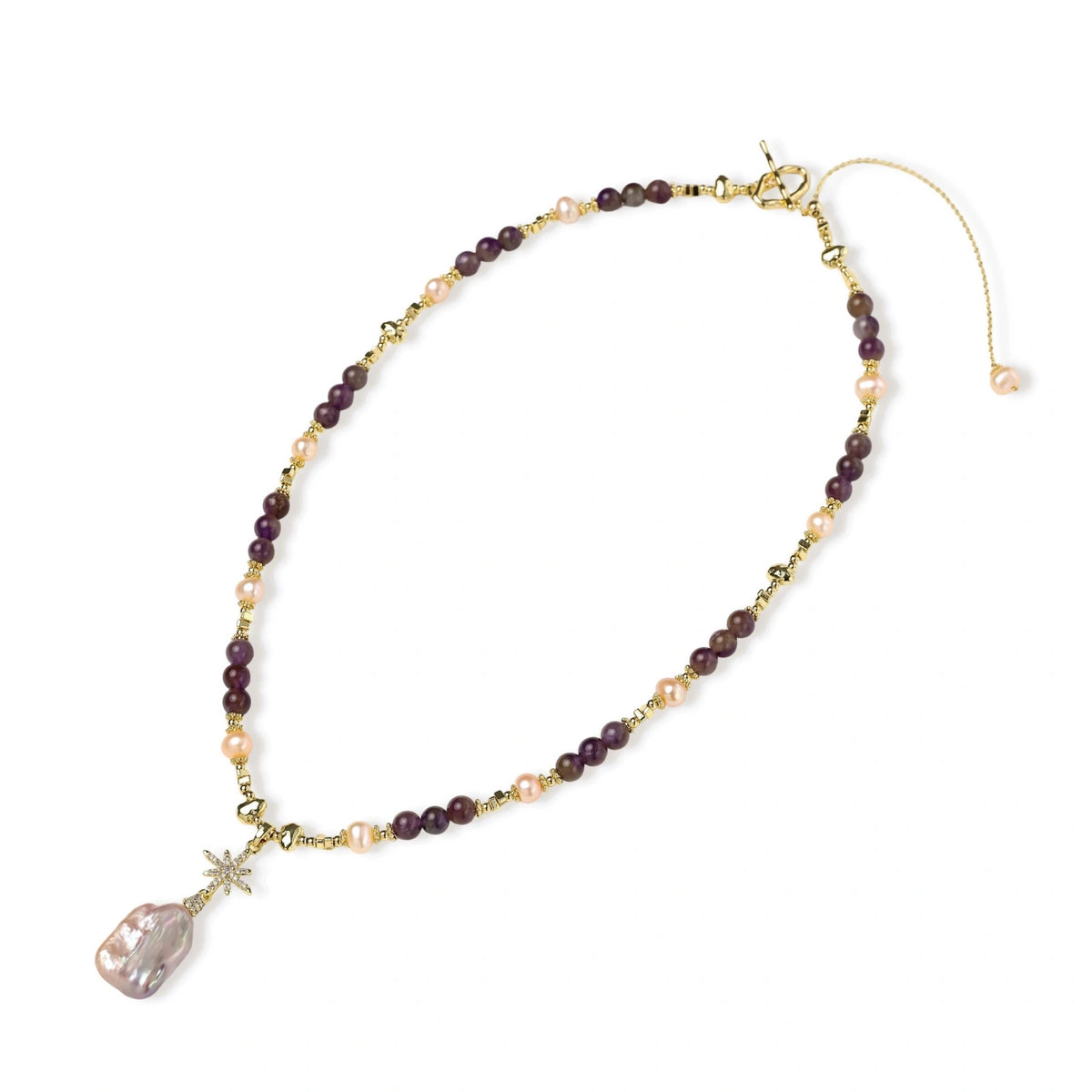 Gold necklace with iridescent baroque pearl pendant, purple amethyst beads, and crystal star charm on cream background