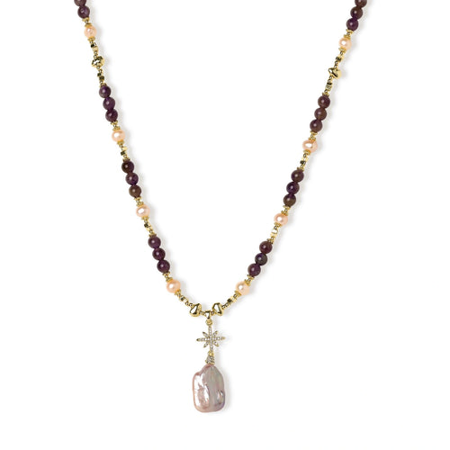 Gold necklace with iridescent baroque pearl pendant, purple amethyst beads, and crystal star charm on cream background